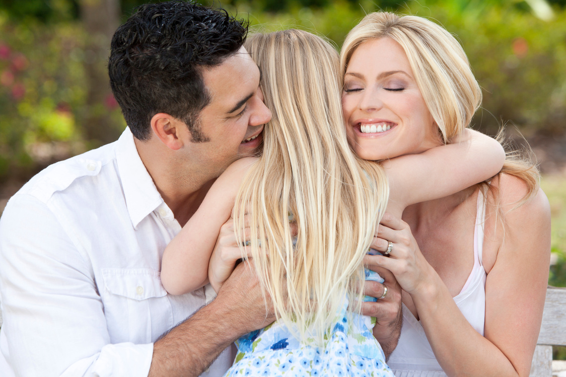 Girl Child Hugging Happy Parents